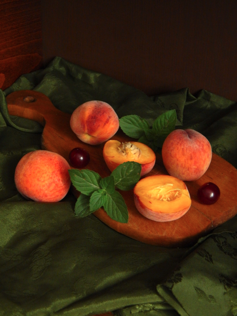 Cut peaches on a cutting board.